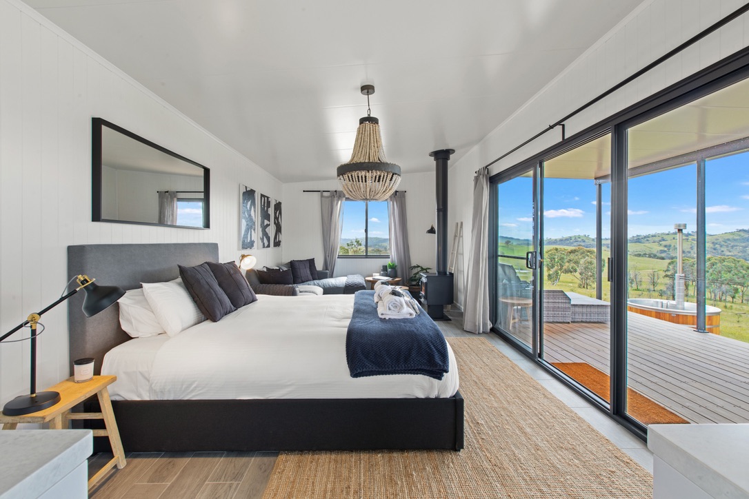 Cabin bedroom with bead chandelier and deck views