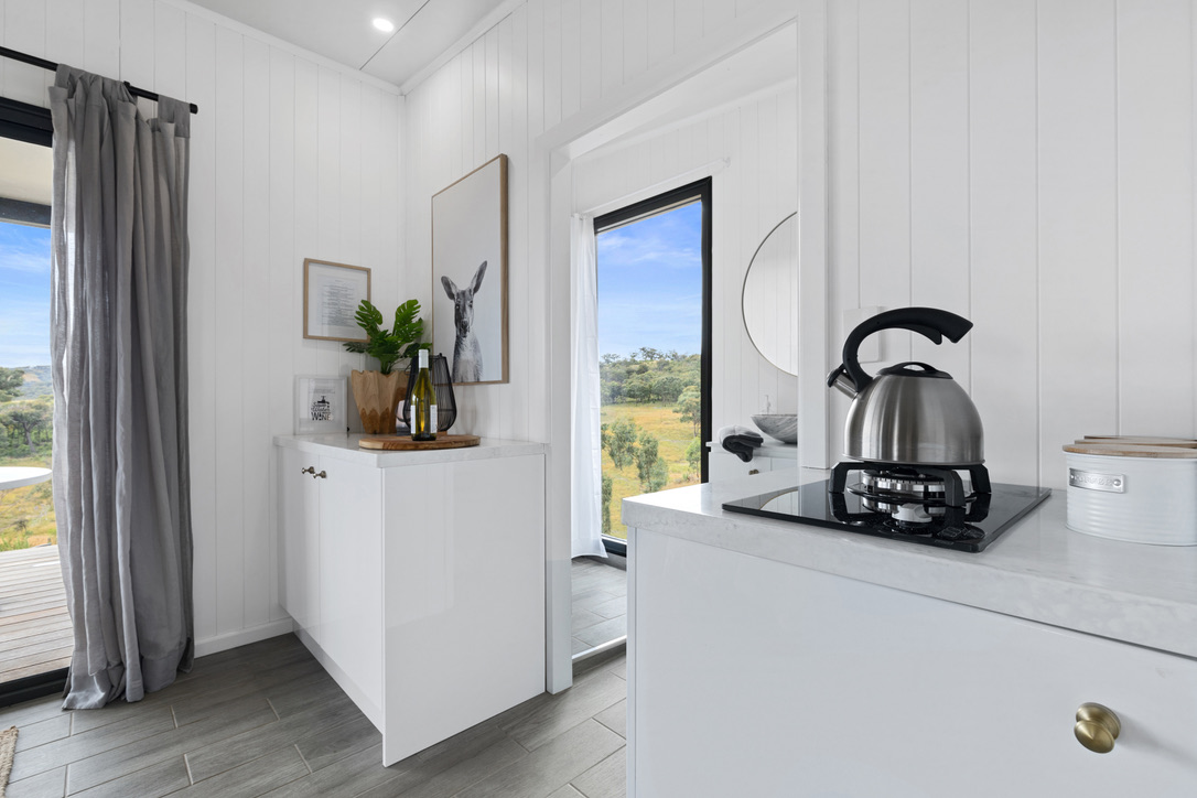 SIPs kitchenette with white cabinetry and country views
