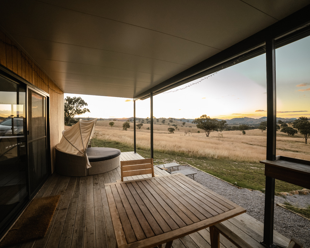 Covered deck at sunset with wicker daybed