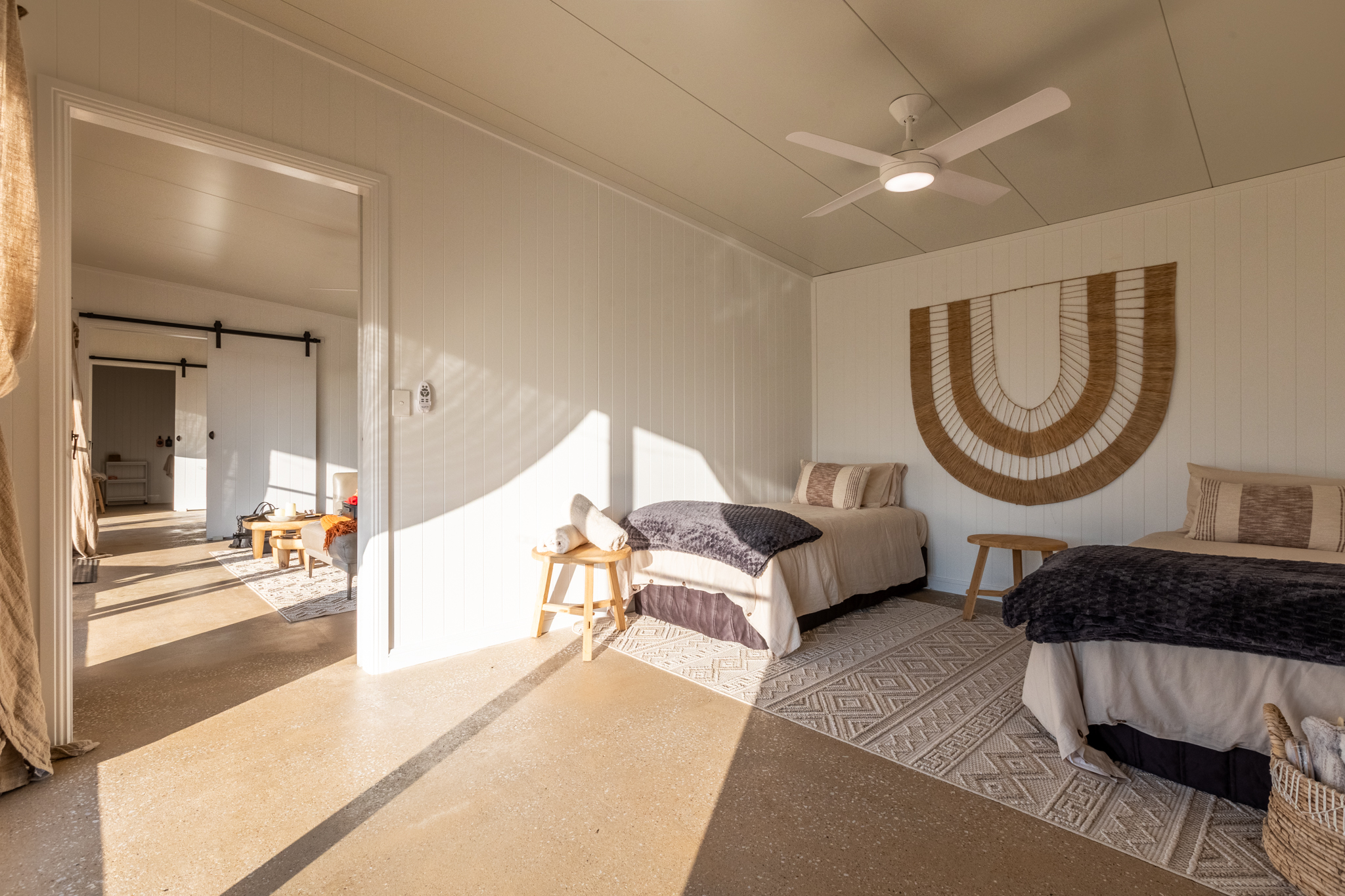 Bedroom with ceiling fan and macramé wall art