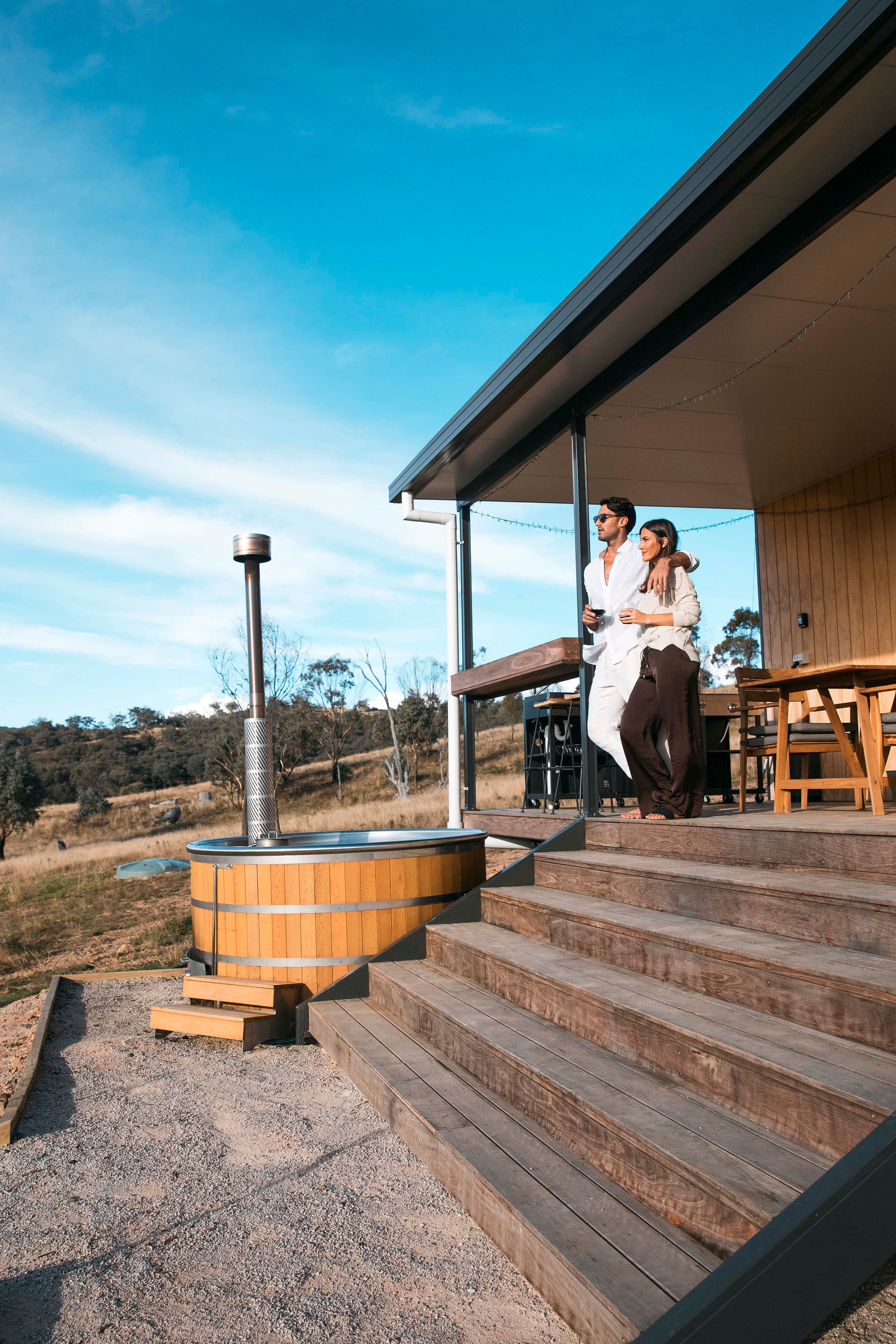 Couple relaxing on insulated deck overlooking countryside
